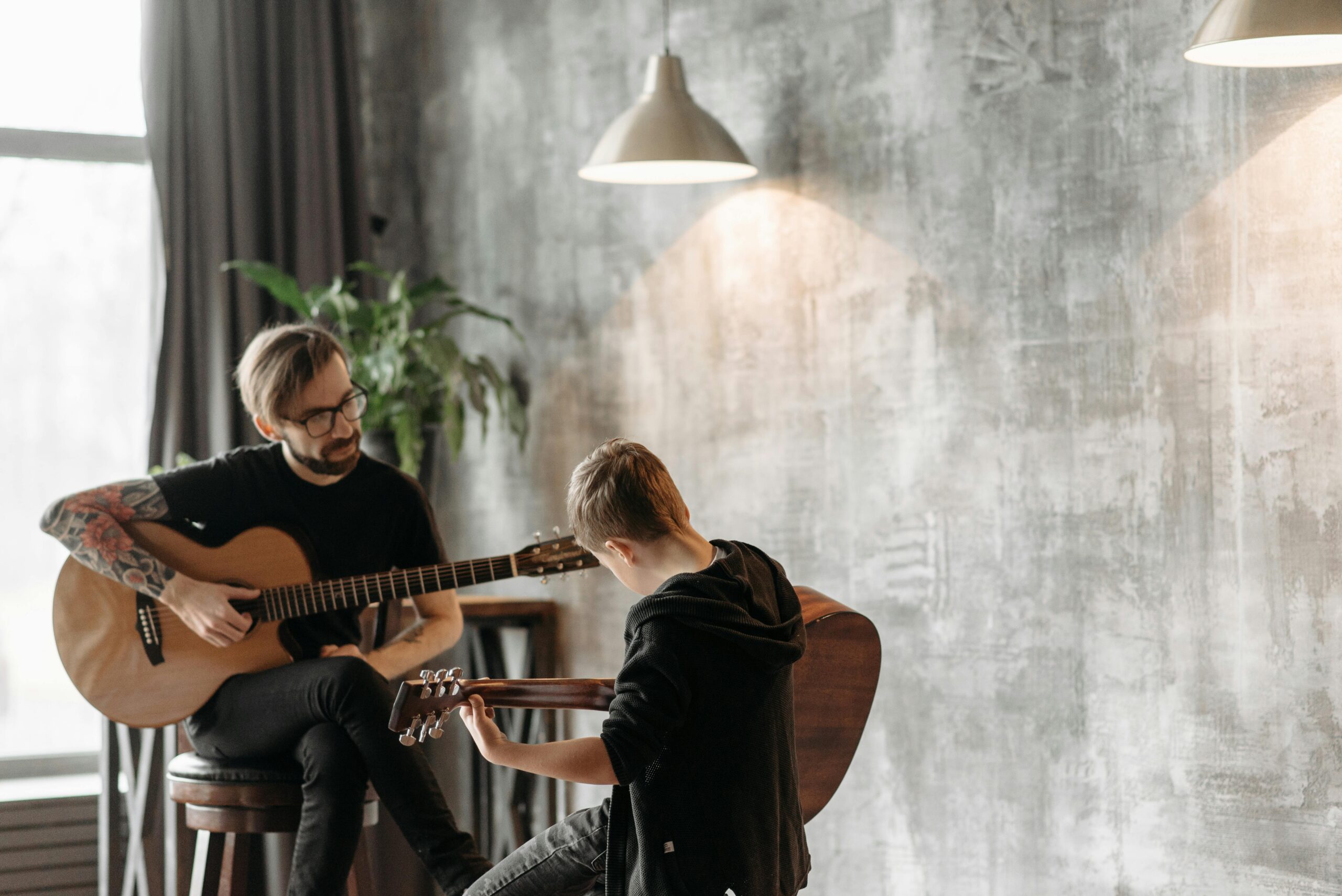 A Man and Boy Doing Guitar Lessons